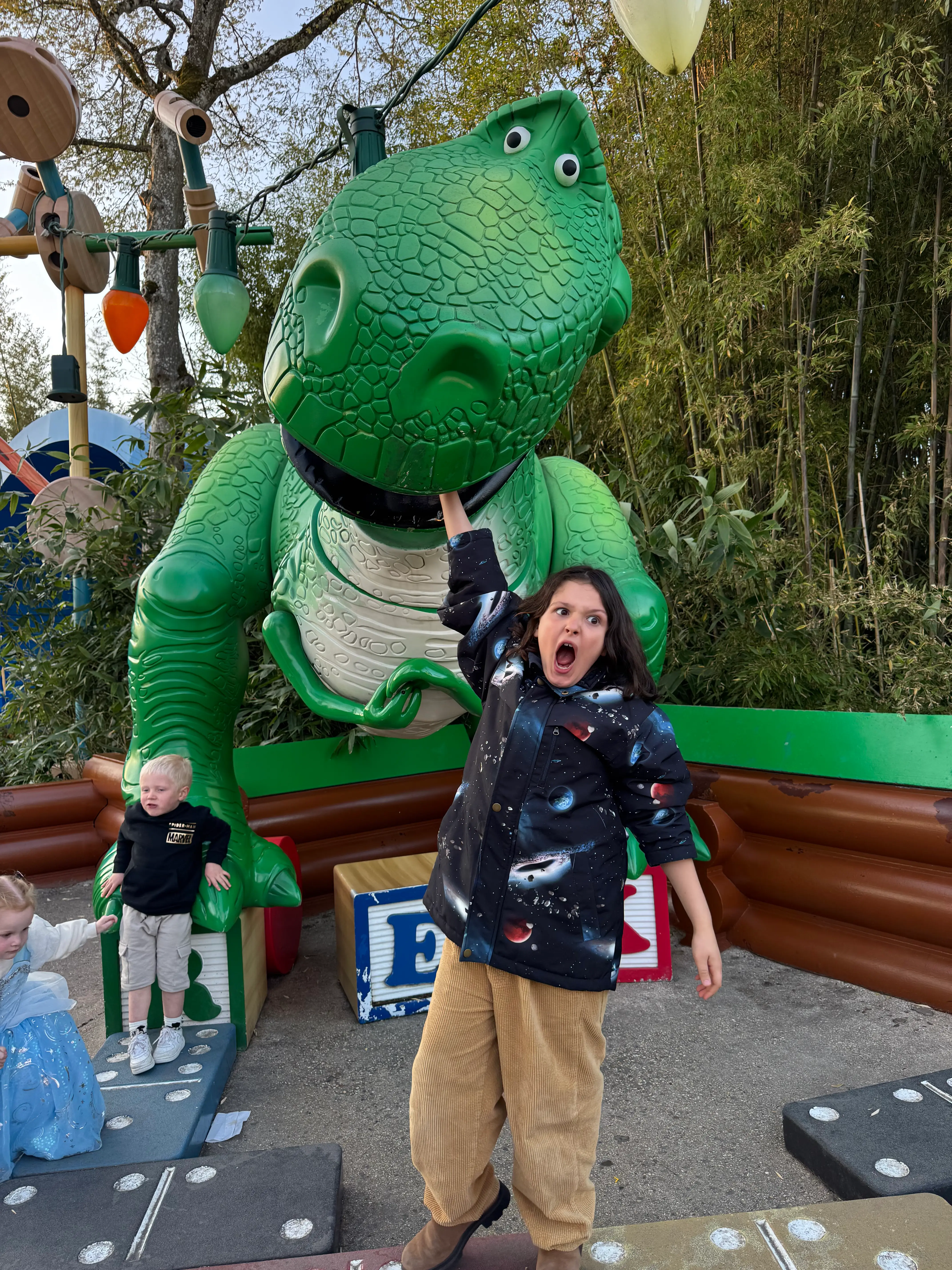 criança com T-rex do toy story na disney