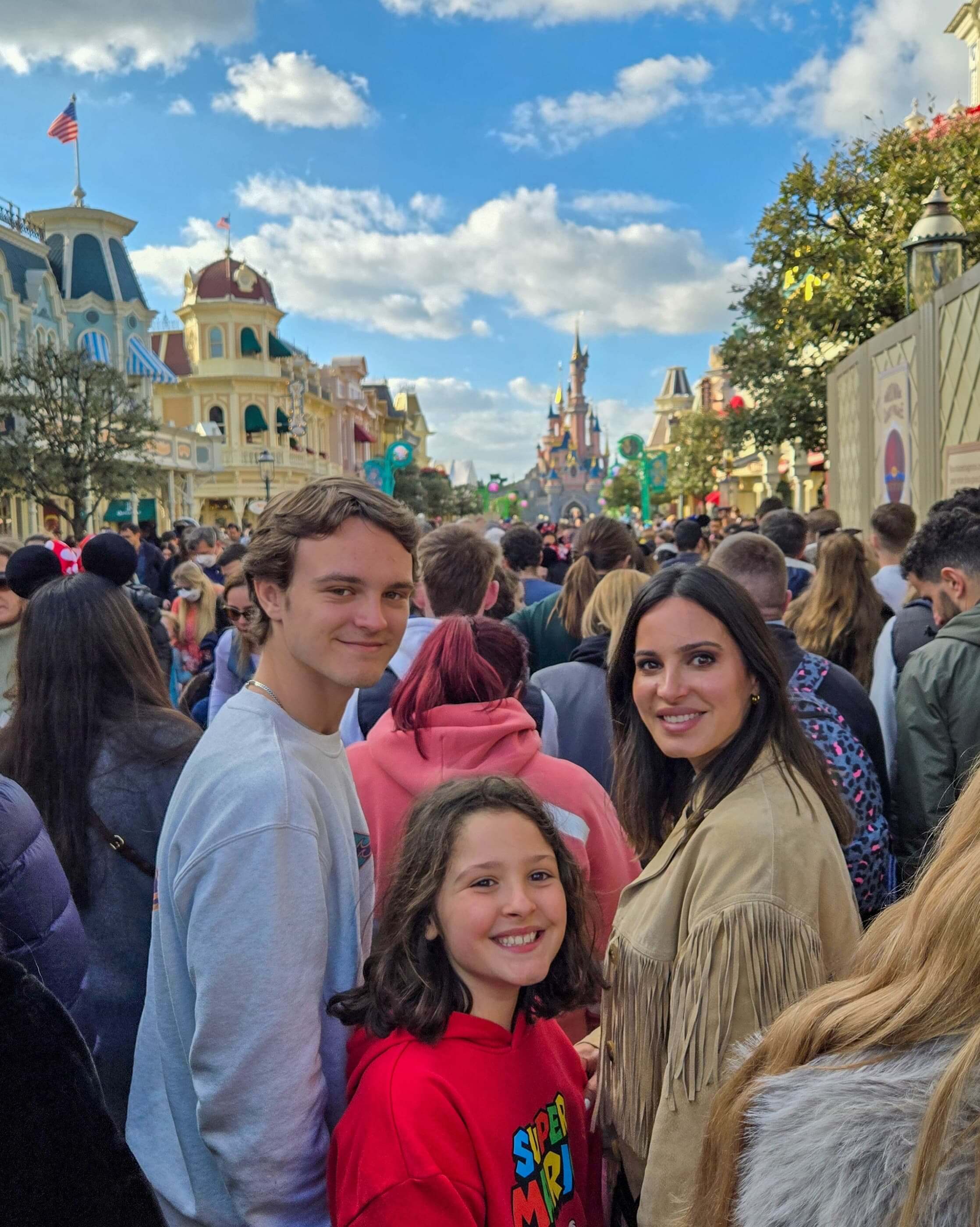 mãe e filhos na disneyland paris felizes na rua