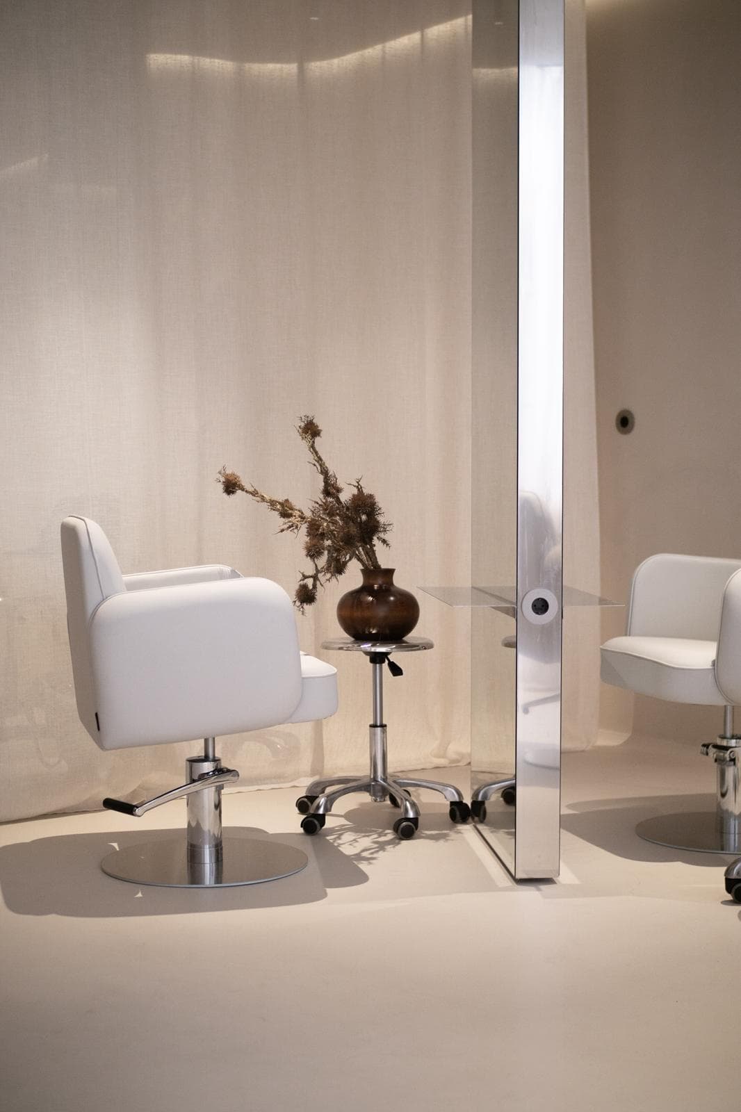 Zona de atendimento da Hush Hair Studio com espelhos e decora&ccedil;&atilde;o elegante