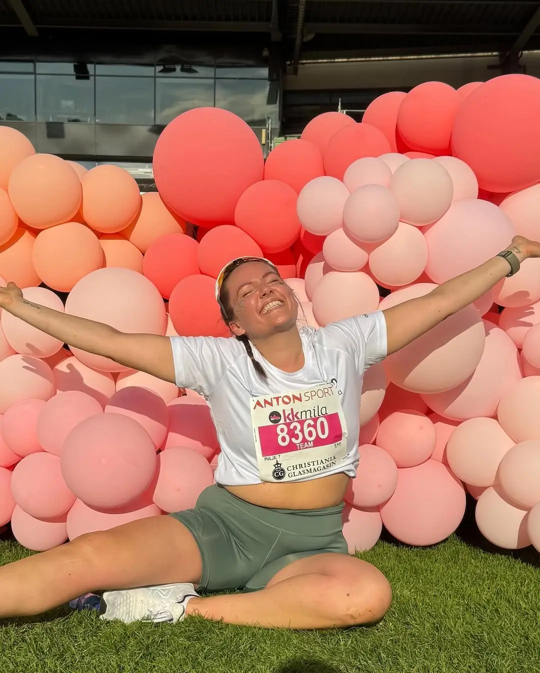 rapariga atl&eacute;tica feliz no meio de bal&otilde;es depois de uma corrida
