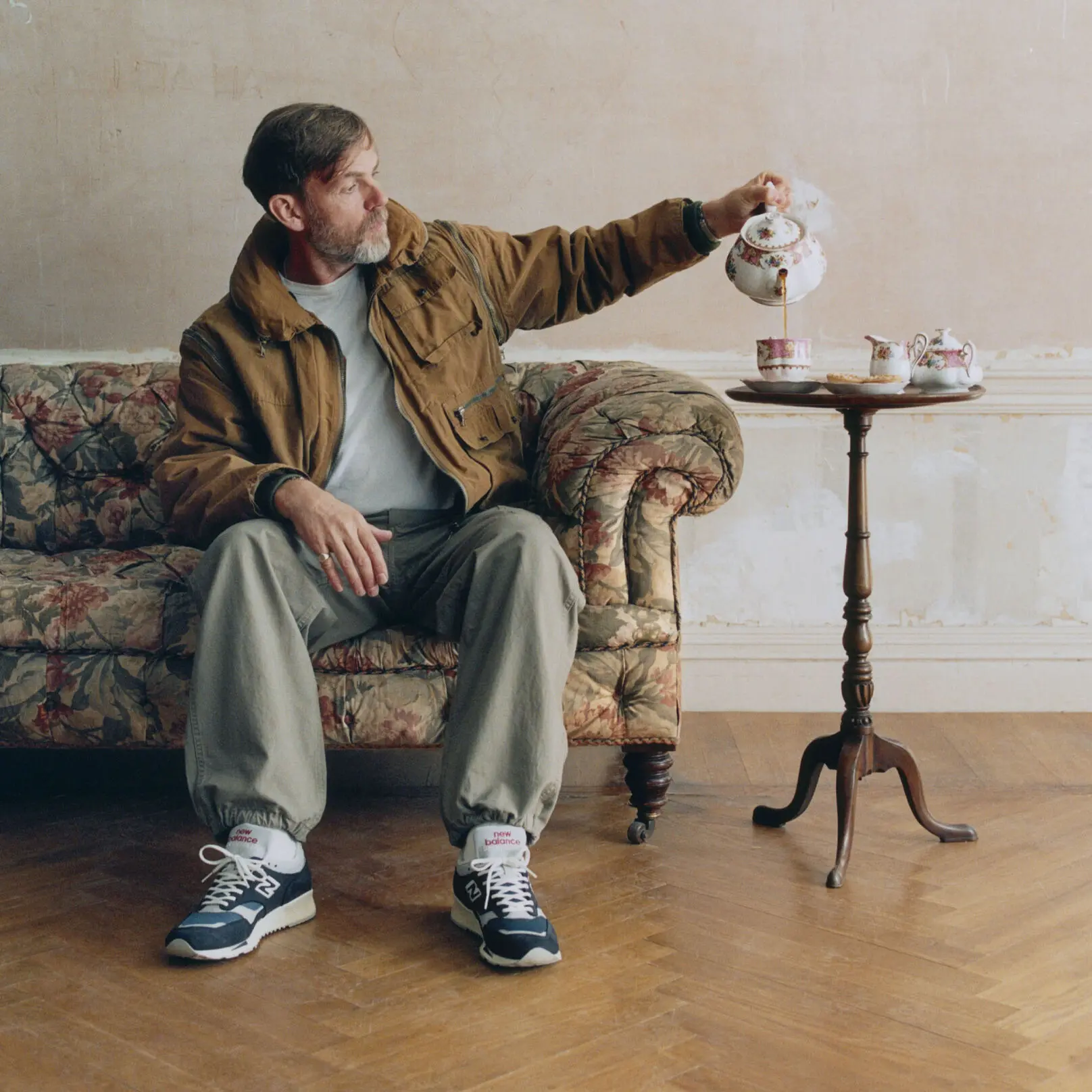 new balance made in uk 1500 homem a servir chá sentado num sofá