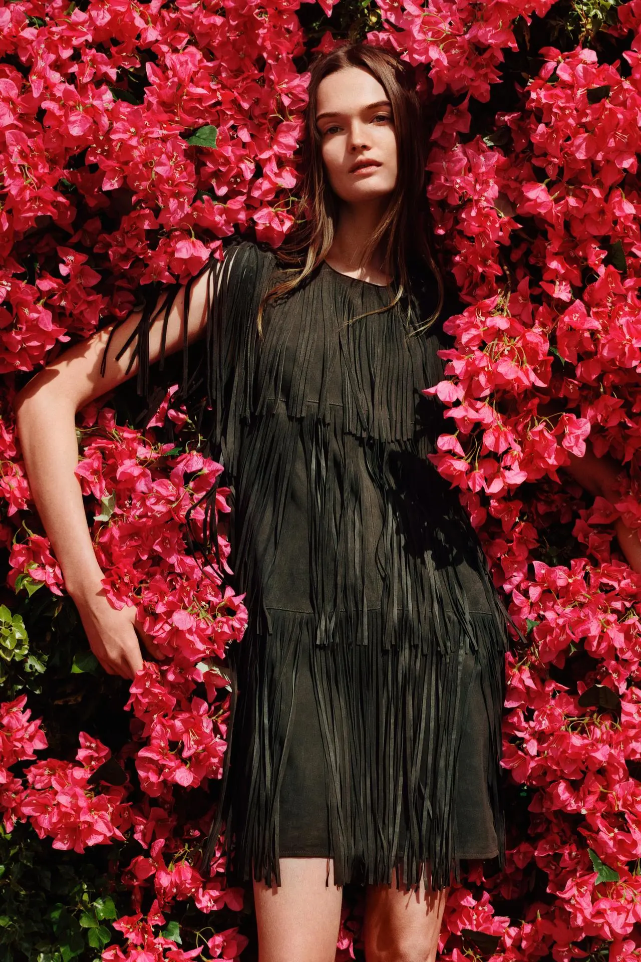 vestido pele franjas zara modelo no meio de flores encarnadas